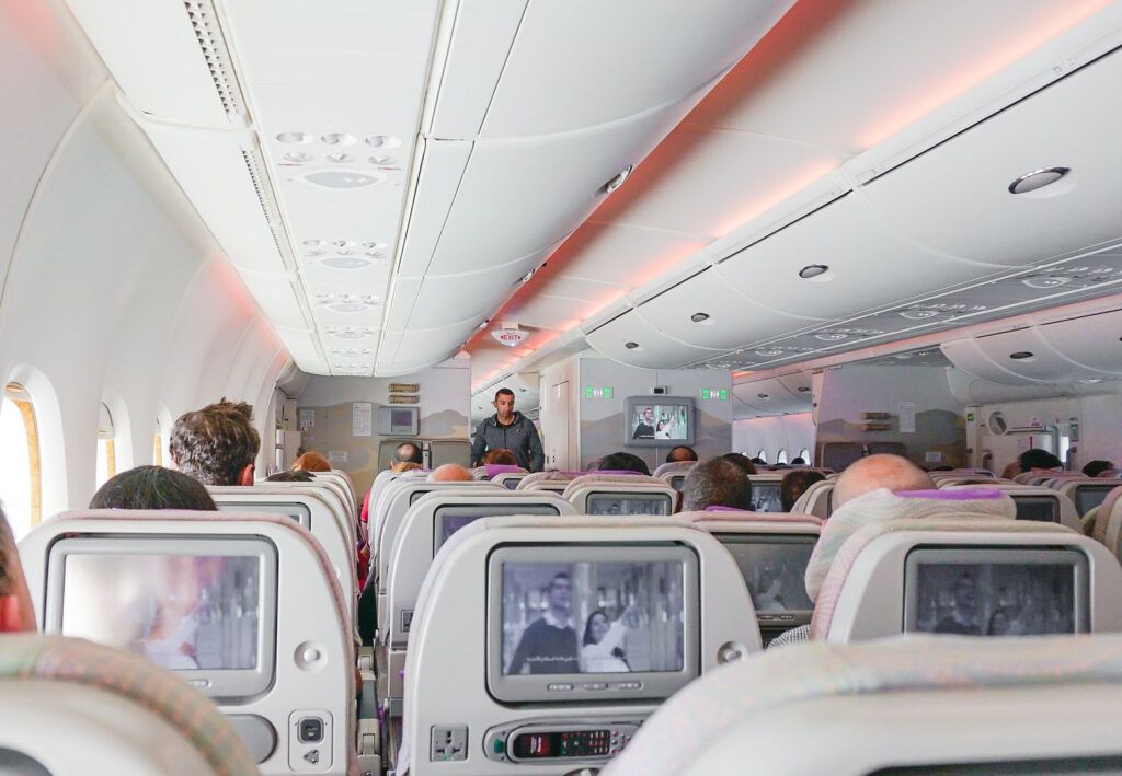 interior de un avión, sillas con pantallas, que sirven para sobrevivir a un largo viaje - weroad