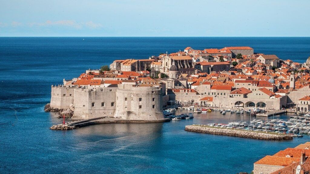 Panoramica bordo mare della città di Dubrovnik con barche a vela 