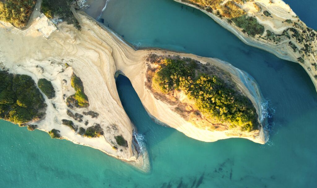 Vista aerea di formazioni rocciose bianche con vegetazione verde e mare turchese