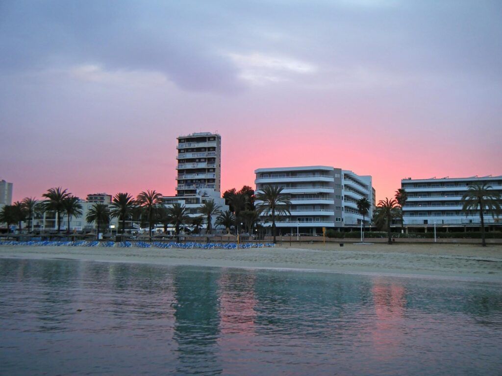 Hotel si affacciano sulla spiaggia con palme di Magaluf al tramonto