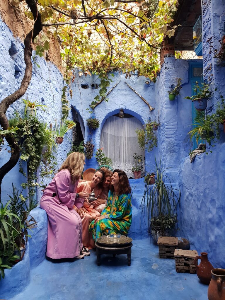 Ragazze nella città blu in Marocco con una teiera e vestiti tradizionali