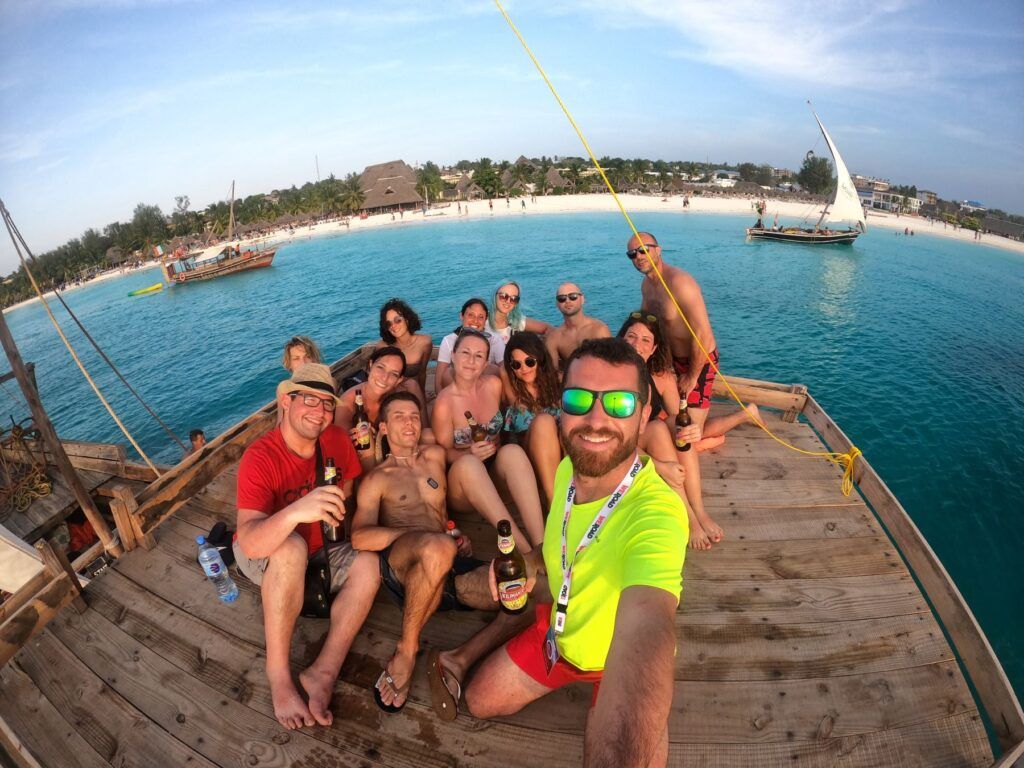 Un gruppo di persone beve su una barca al tramonto a Zanzibar