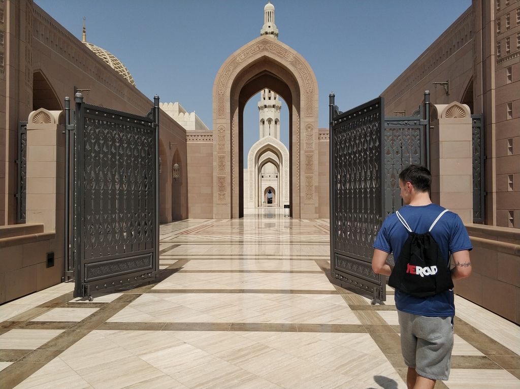 ragazzo all'entrata della grande moschea Sultan Qaboos a Muscat