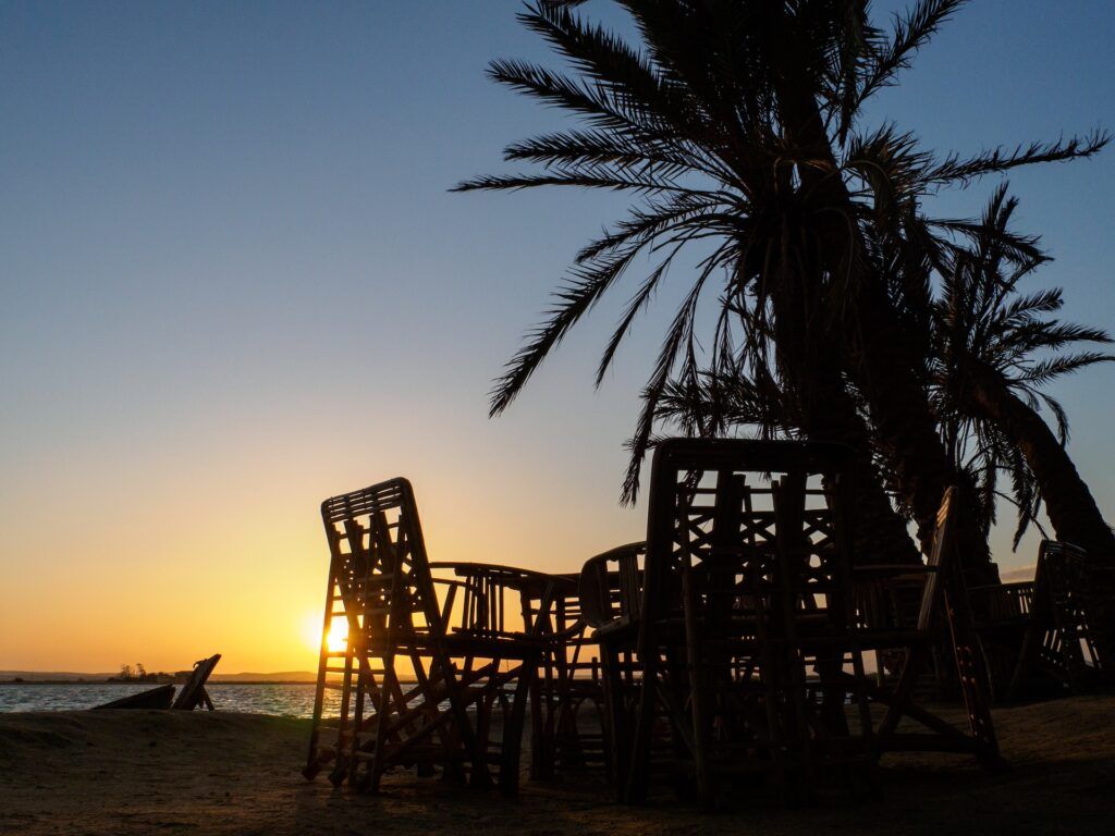 Un tavolino e delle sedie nell'oasi di Siwa al tramonto