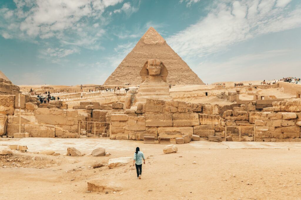 una persona cammina verso la Sfinge a Giza