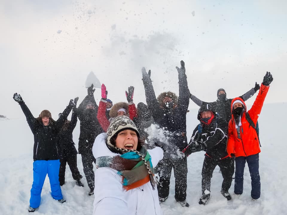Un gruppo di persone sorride in mezzo alla neve in Svezia