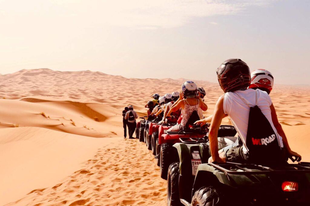 Un gruppo di persone attraversa il deserto del Marocco su dei quad