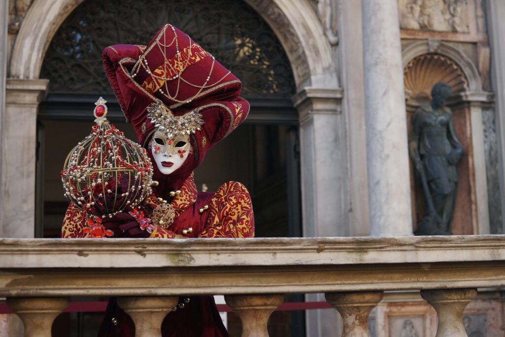 Una donna indossa una tipica maschera del carnevale veneziano
