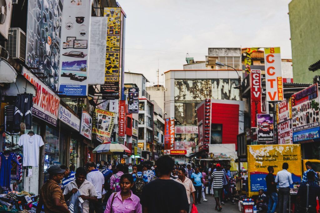 Persone camminano nelle affollate di strade di Colombo, nel quartiere Pettah