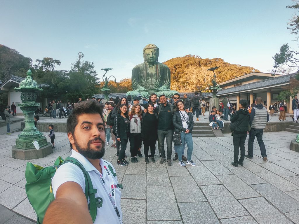 Foto di un gruppo di weroaders che si fanno un selfie davanti al tempio di buddha a Kyoto