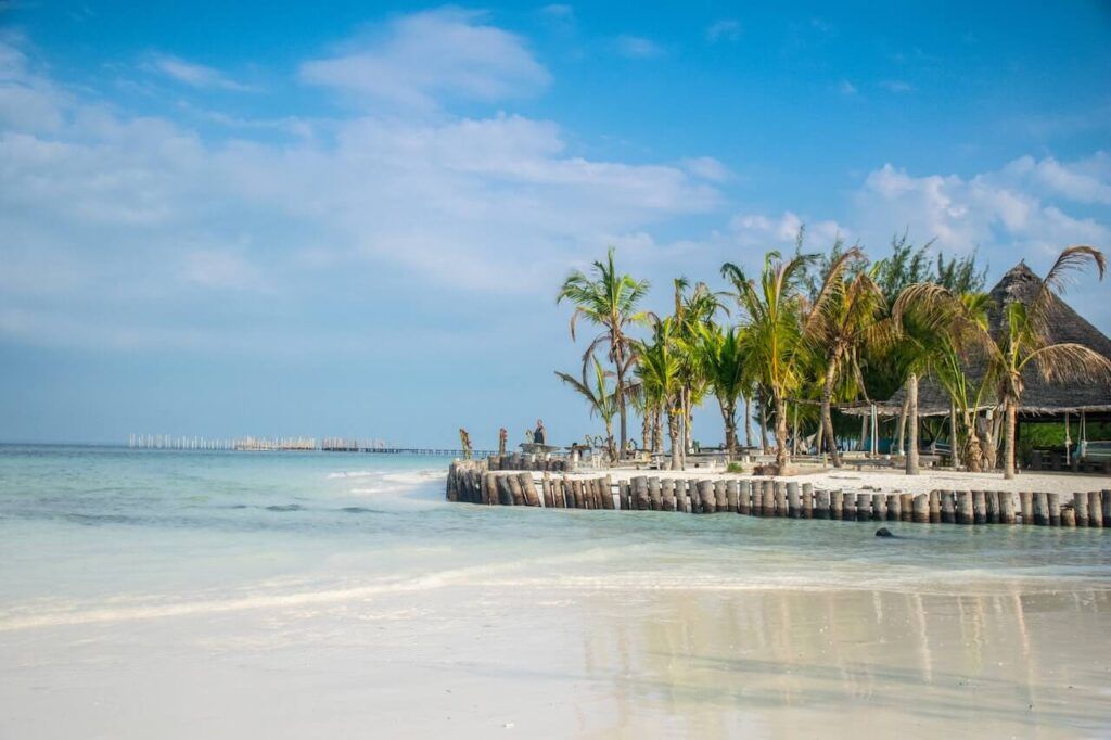Una spiaggia di sabbia bianca con palme e capanna sulla costa di Zanzibar