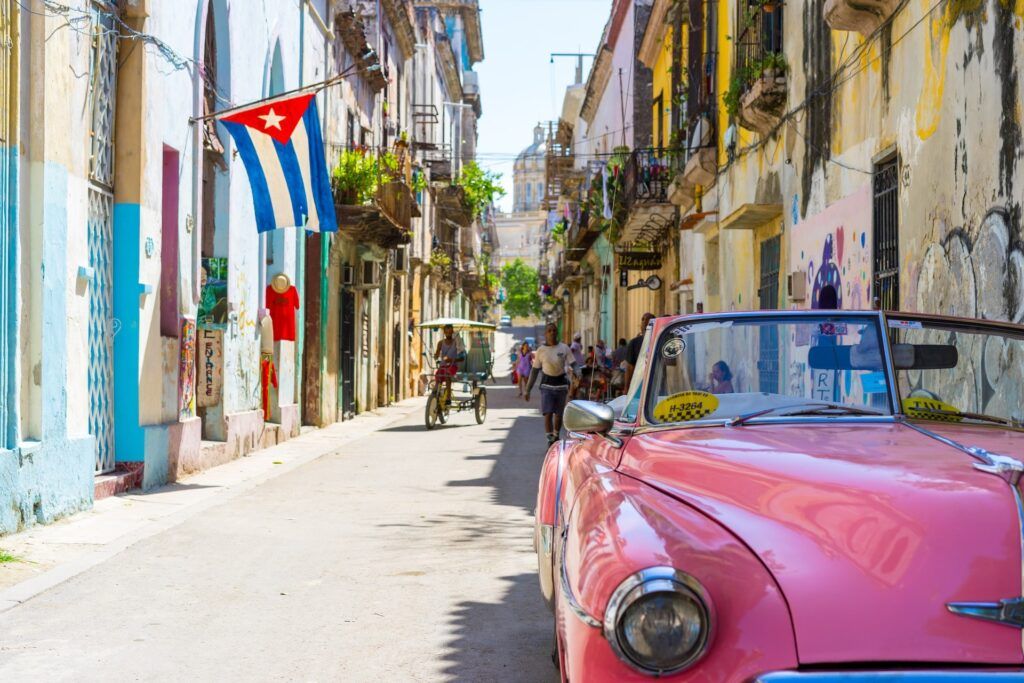 Una tipica auto rosa in una strada di Cuba
