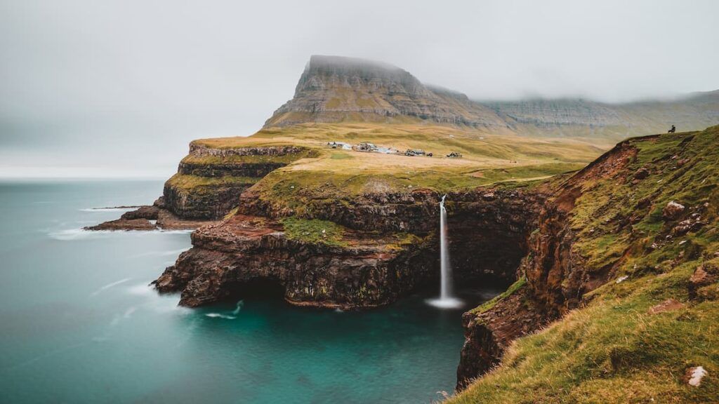 Le scogliere verdi delle isole Faroe nella nebbia