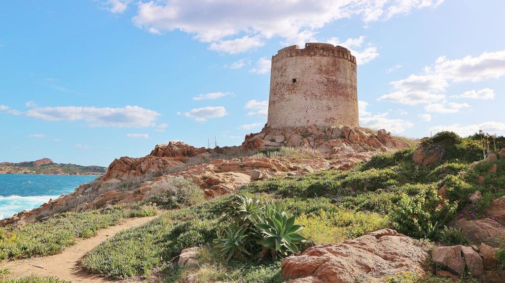 una antica torre in pietra su un terreno roccioso