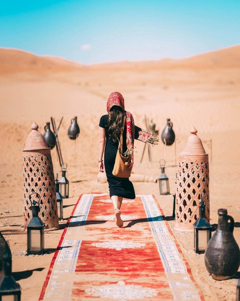 una donna vestita di nero cammina nel deserto