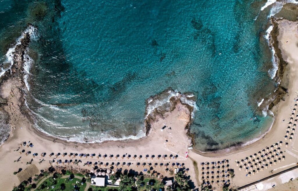 sabbia rocce e ombrelloni sulla spiaggia di Malia a Creta