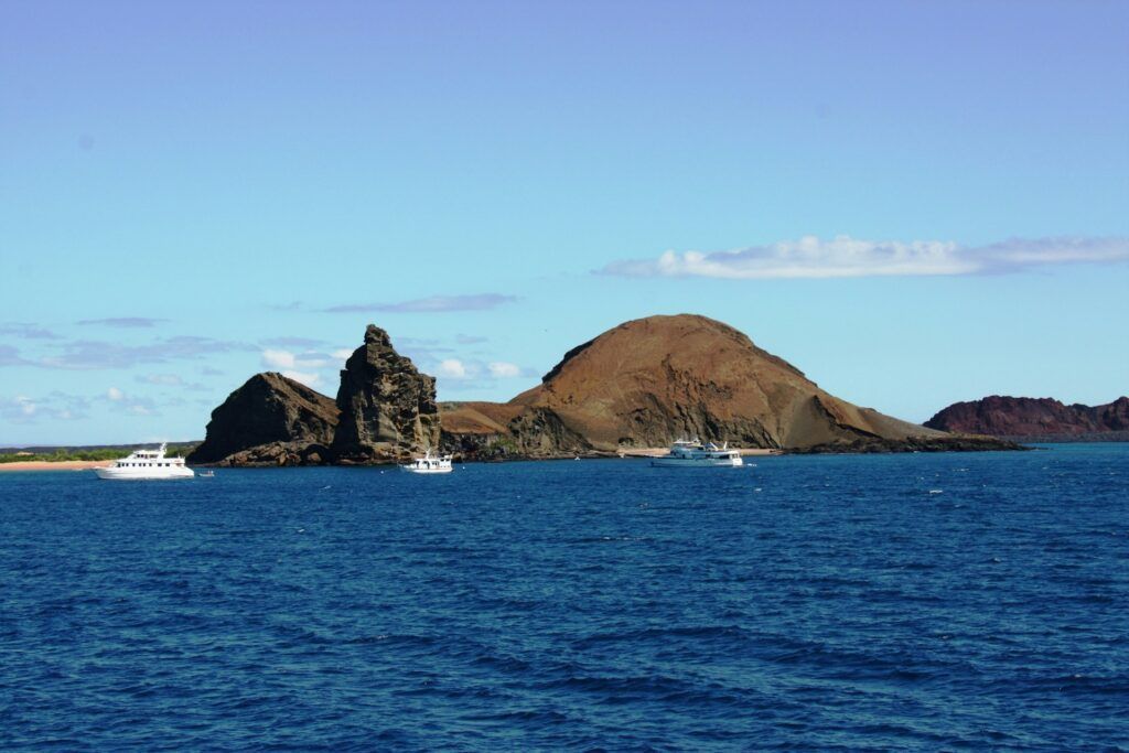 delle imbarcazioni solcano l'Oceano davanti alla costa delle galapagos