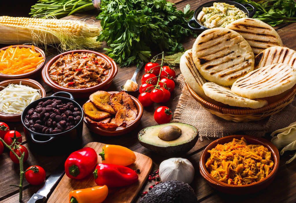 Tavola colombiana con arepas, platano fritto, fagioli, carne e avocado: un'esplosione di colori e sapori che racconta la vera anima del Paese.