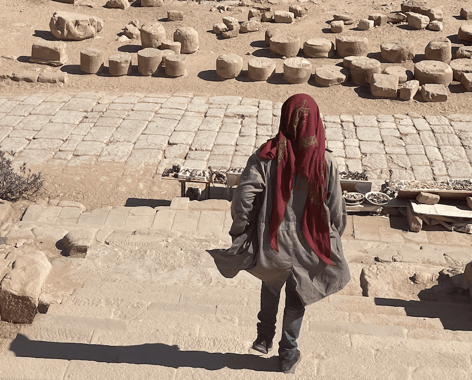 Donna con velo tra le rovine archeologiche di Petra