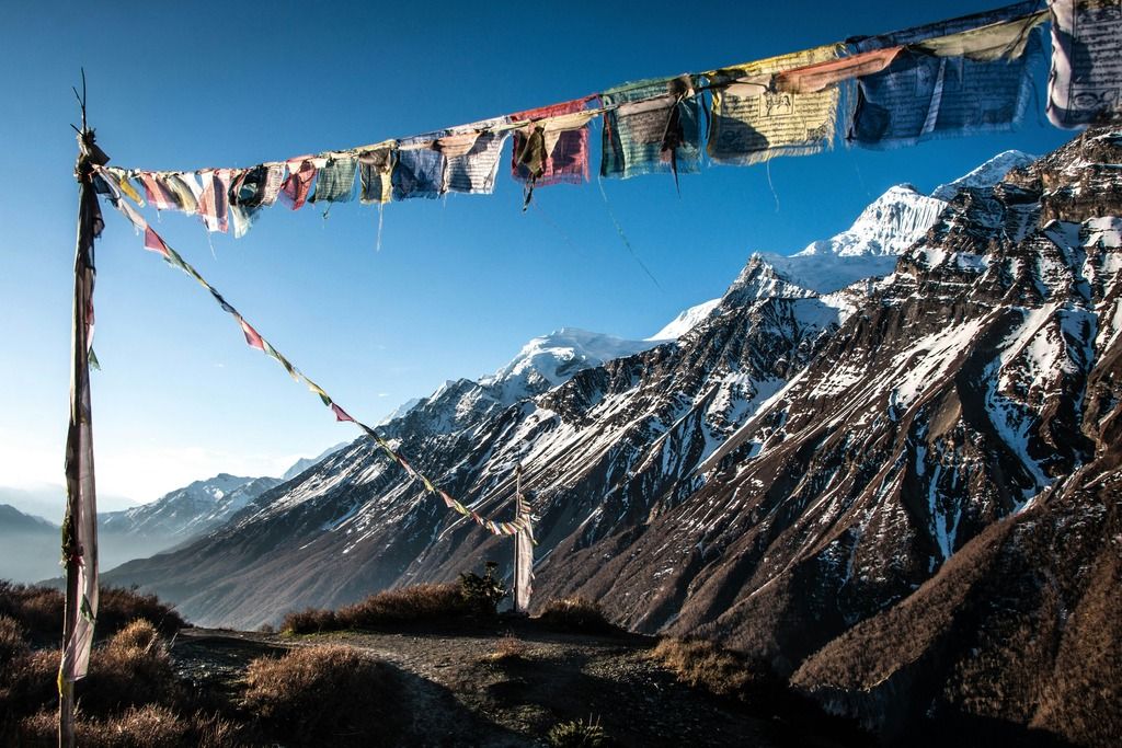 Bandiere di preghiera nel vento tra le vette innevate dell’Himalaya