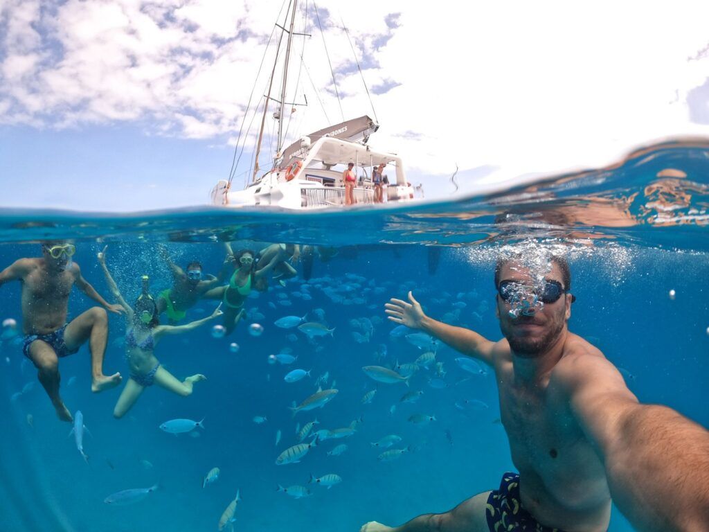 Gruppo di viaggiatori WeRoad durante un Island hopping che fa snorkeling tra pesci colorati, in acque cristalline