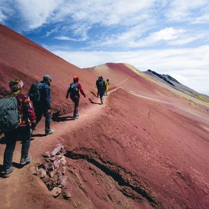 Viaggiatori WeRoad camminano lungo i sentieri colorati della Montagna Arcobaleno