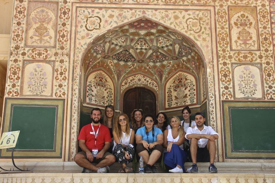Weroaders seduti davanti a portale decorato nel Rajasthan