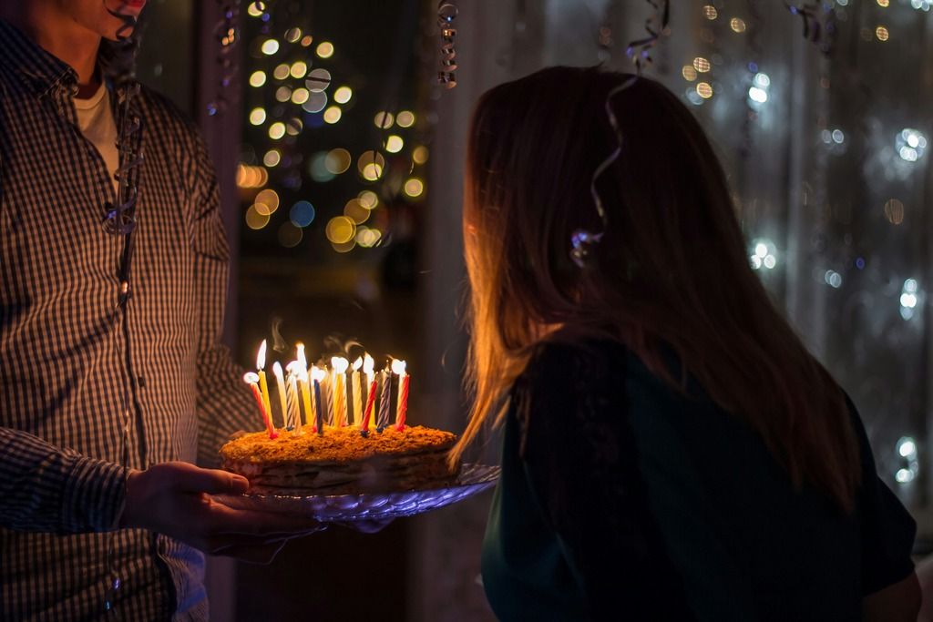 Ragazza soffia le candeline su una torta di compleanno.