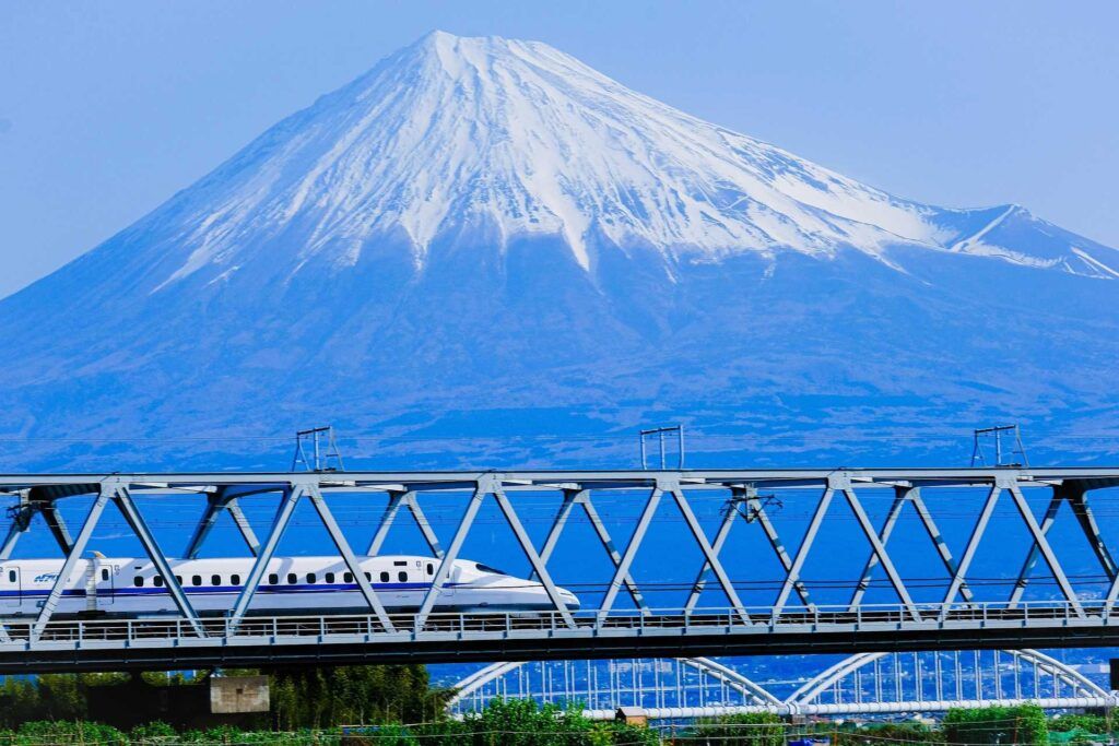 Treno in corsa con il monte Fuji nello sfondo.