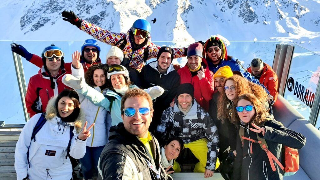 Gruppo di WeRoaders a Livigno sulla neve con montagne innevate sullo sfondo