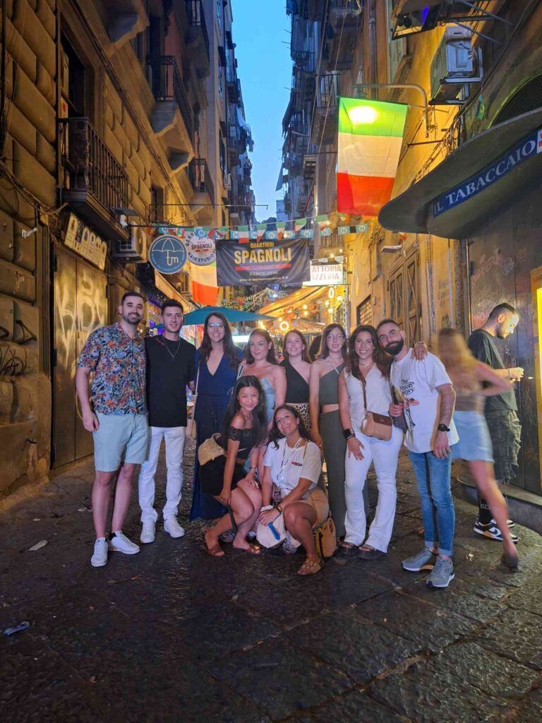 Gruppo WeRoad in un vivace vicolo di Napoli.